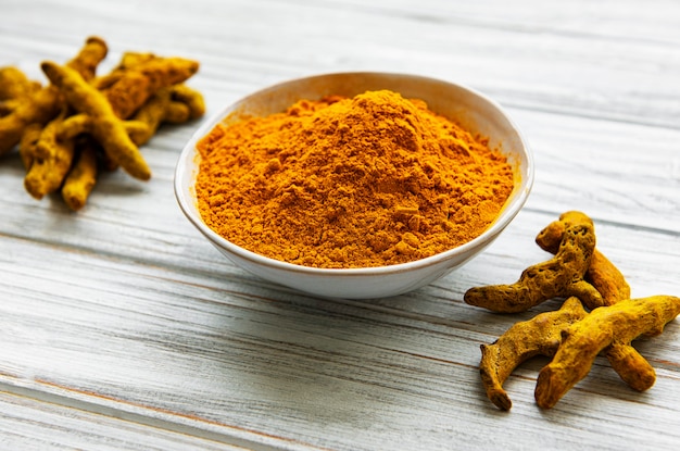 Yellow turmeric powder and dry roots