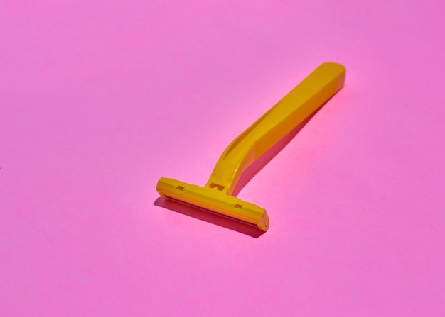 Yellow unisex razors on pink background