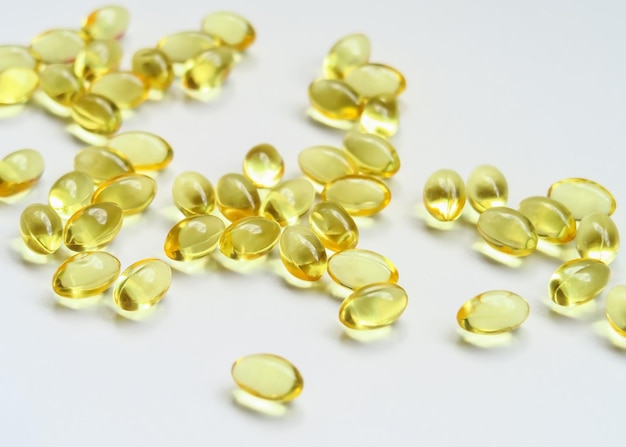 yellow vitamin capsules on a white background food supplements health care concept