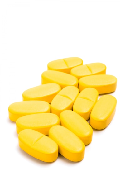 Yellow vitamin pills isolated on white beckground