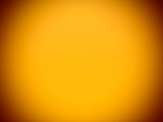 Yellow vivid abstract background a beautiful rich yellow color close to ocher dark orange vignetting around the edges