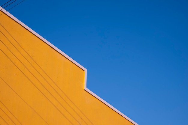 A yellow wall with a blue sky in the background.