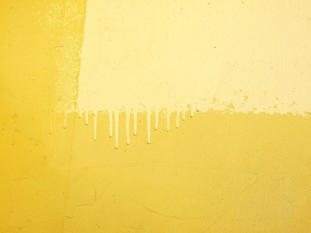 A yellow wall with streaks of paint yellow background