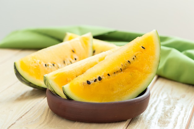 Yellow watermelon sliced on wood