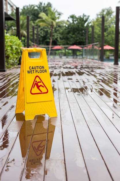 Photo yellow wet floor warning sign on the floor in hotel corridor