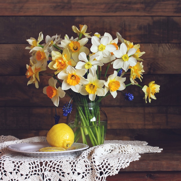 Yellow and white daffodils of different varieties in a glass vase