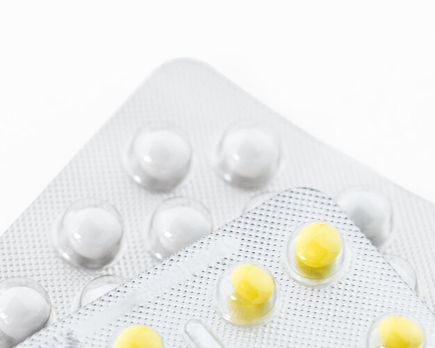 Желтые и белые таблетки в пластиковой упаковке копируют пространство Концепция здравоохранения и медицинского страхования
