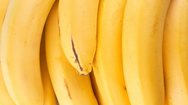 Le banane intere gialle si chiudono sullo sfondo