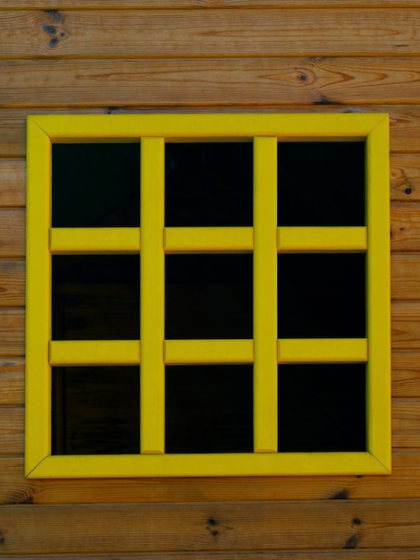 Yellow window and wooden wall