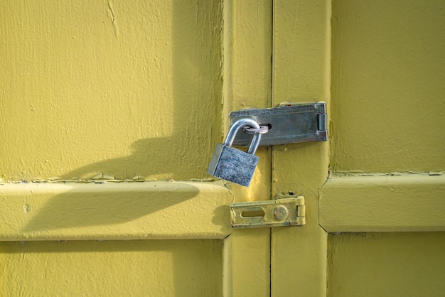 Yellow wood door closed with padlock