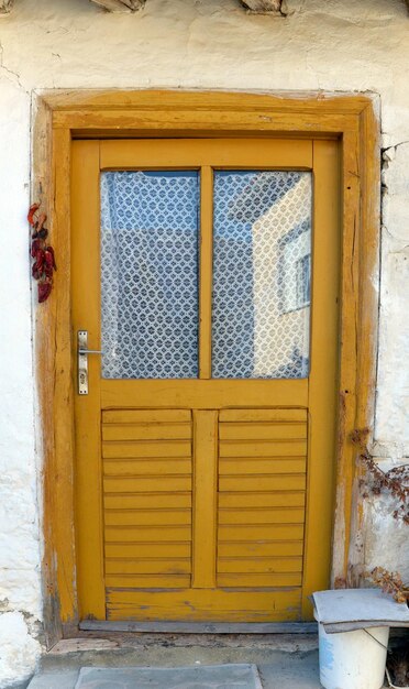 Photo a yellow wooden door with a sign that says  hinge  on it