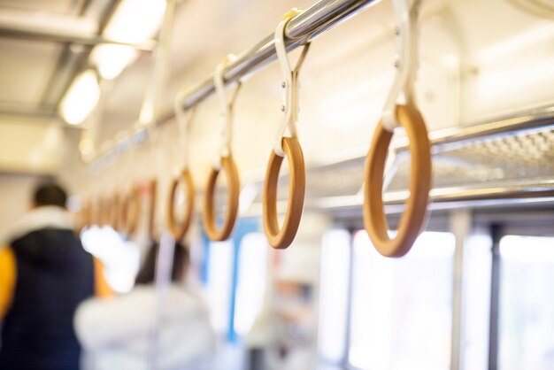 Yellow wooden  hand grip straps inside subway train