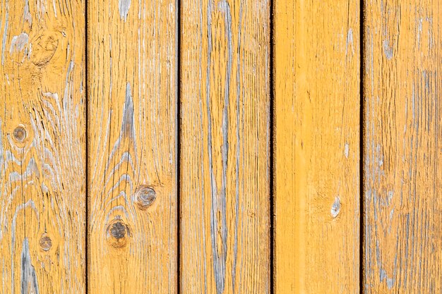 Yellow wooden peeling wall. Old painted vertical boards. Textured Background.