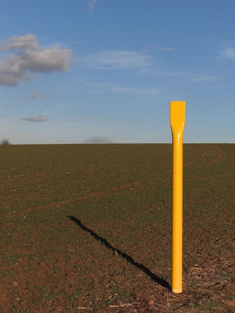 Foto palo di legno giallo sul campo contro il cielo