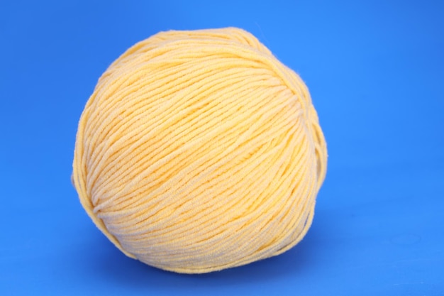 Foto palla di lana gialla su sfondo blu. foto di alta qualità