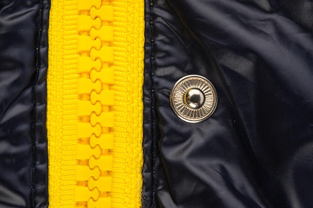 검은색 광택 직물로 만든 재킷의 노란색 지퍼 잠금 장치