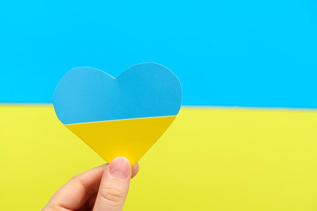 Yellowblue heart in the color of the flag of Ukraine in the hand of a person