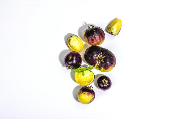 白い背景に分離された黄紫トマト品種原色