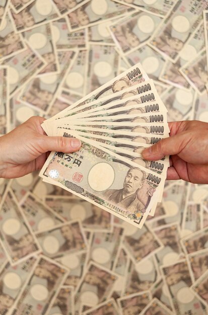 YEN Японские деньги Руки держат оплату при получении банкноты 100000 иен