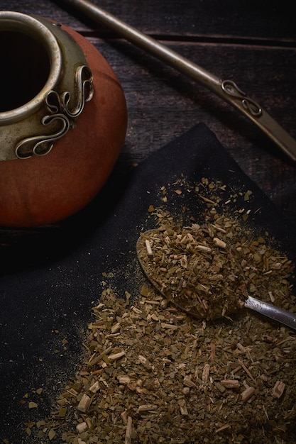 Yerba mate en kalebas met bambilla op een zwarte houten achtergrond