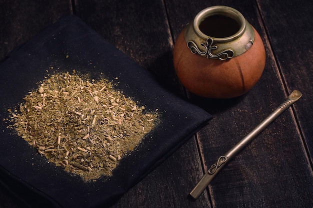 Yerba mate en kalebas met bambilla op een zwarte houten achtergrond