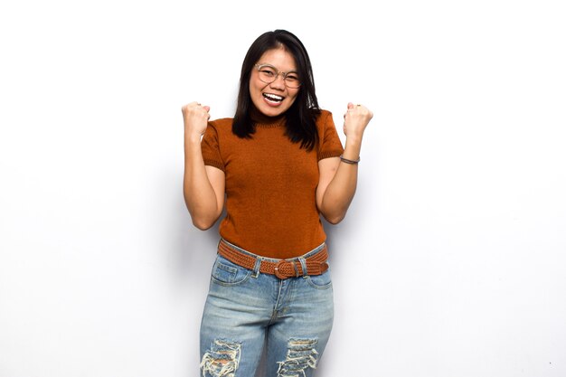 Yes or excited gesture of Young beautiful asian women dress orange shirt isolated on white