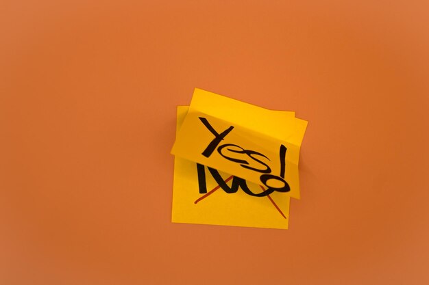 Photo yes note over no note yellow notes over orange background