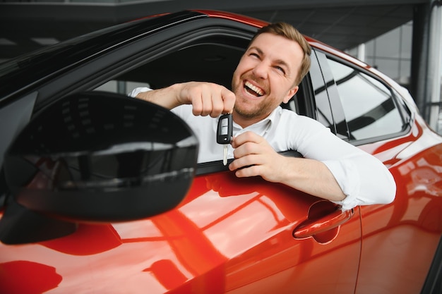 Yes that's my new car Customer in car dealership Young man with keys in hand