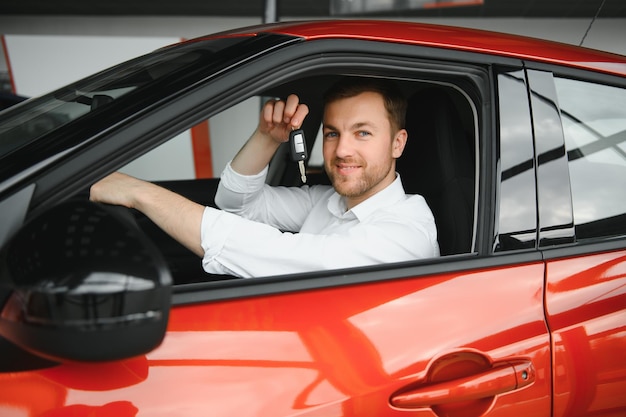 Yes that's my new car Customer in car dealership Young man with keys in hand