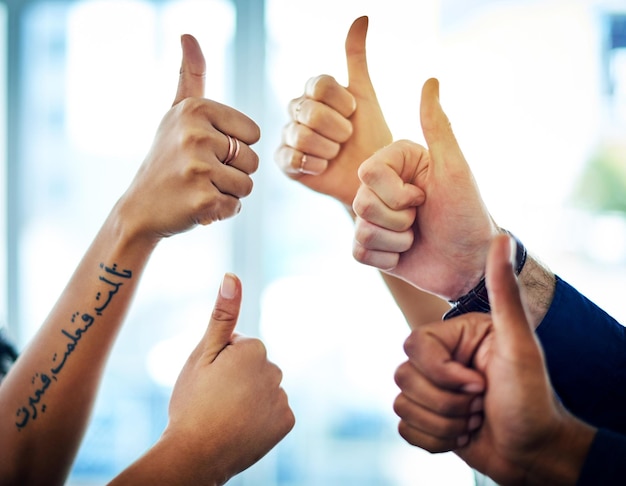 Yes We are the best team Cropped shot of a group of unrecognizable businesspeople showing thumbs up in a modern office