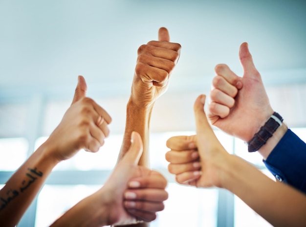 Yes yes theres no turning back Cropped shot of a group of unrecognizable businesspeople showing thumbs up in a modern office