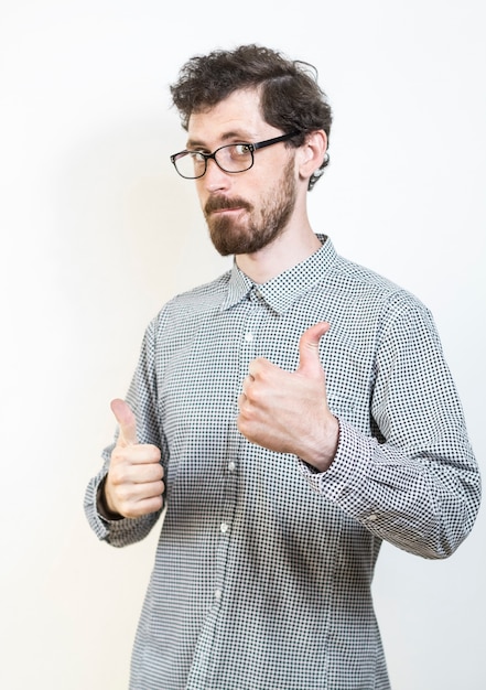 Photo yes! young man pointing thumb up. the guy shows a sign of approval.