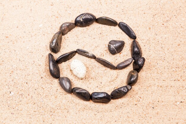 Yin yang drawn with pebbles on the sand of a beach