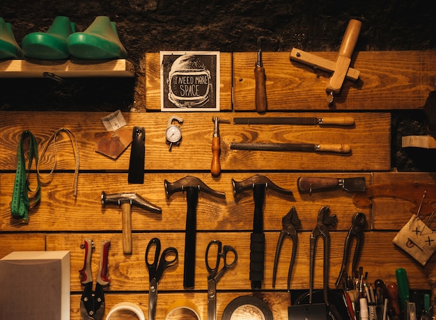 Ynstruments sulla parete di legno all'officina delle calzature.