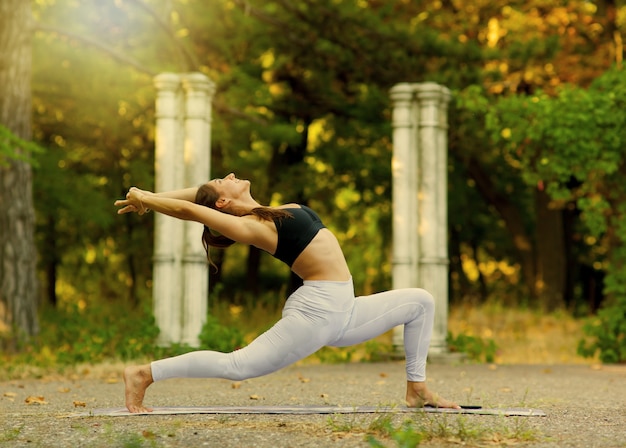 Yoga en fitness. Jonge vrouw beoefenen van balanceren yoga pose buiten