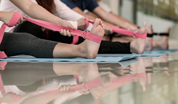 Yoga en meditatie beginnersles voor diversiteitsmensen bij fitness. Training en lichaamsbeweging voor gezond. Aziatische vrouw met man voor groepsactiviteit en levensstijl.