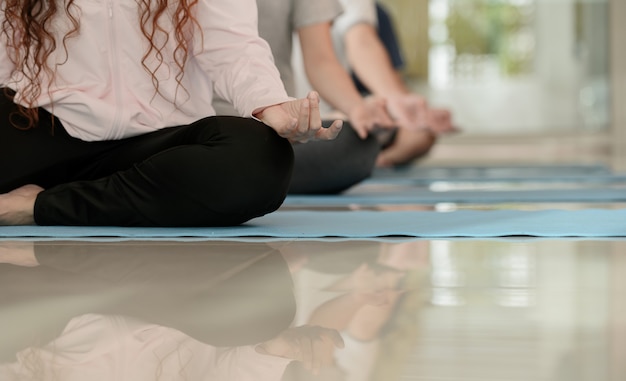 Yoga en meditatie beginnersles voor diversiteitsmensen bij fitness. Training en lichaamsbeweging voor gezond. Aziatische vrouw met man voor groepsactiviteit en levensstijl.