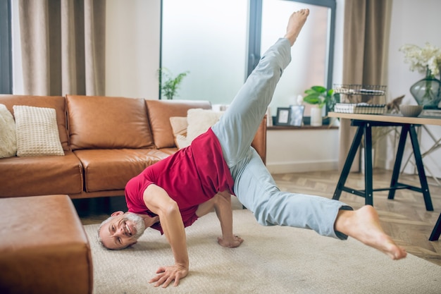 Yoga. grey-haired good-looking man doing yoga and feeling good