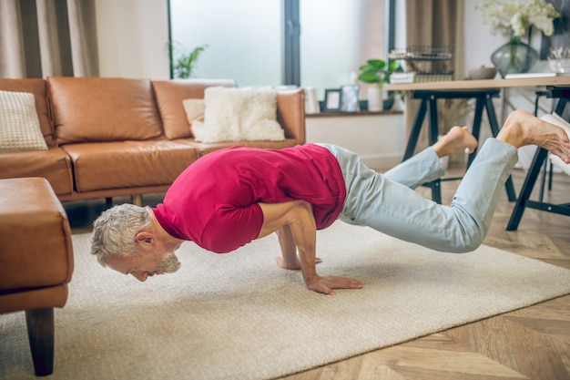 Yoga. Grijsharige fit man doet yoga en ziet er sterk uit