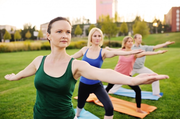 Yoga group on the background of green grass