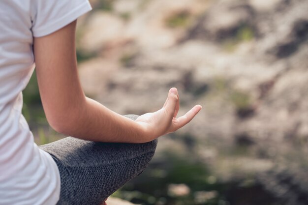 Yoga in het park. Close-up handen van vrouw meditatie doen