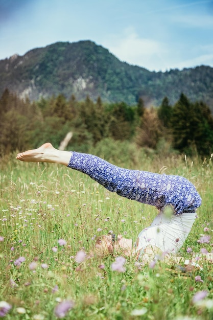 Yoga in het park Jong blank meisje doet yoga buiten zomertijd