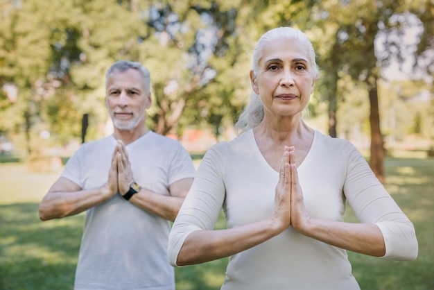 Yoga in het park Senior familiepaar dat buiten traint