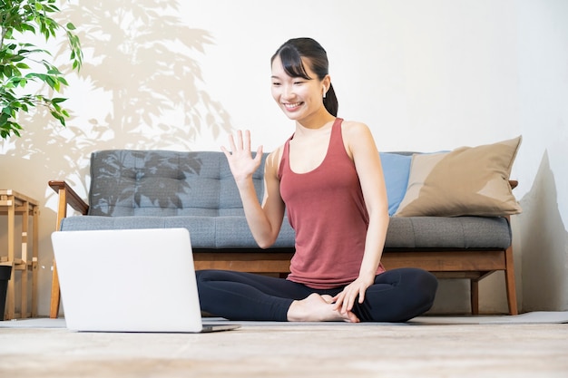 Yoga-instructeur praten met het computerscherm in de kamer