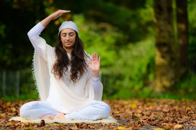 Yoga instructor practices exercises in the park in autumn