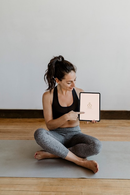 Foto istruttore di yoga che mostra una tavoletta digitale