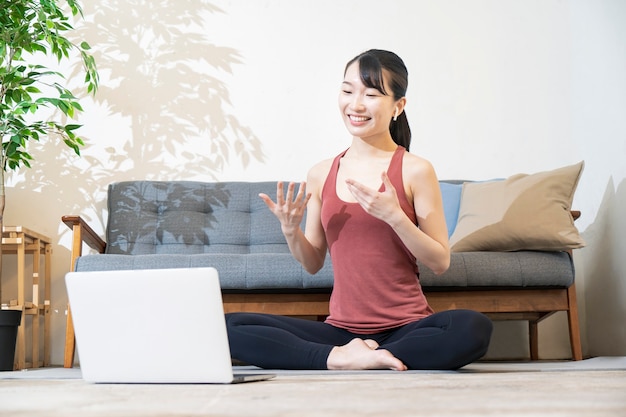 Istruttore di yoga che parla allo schermo del computer in camera