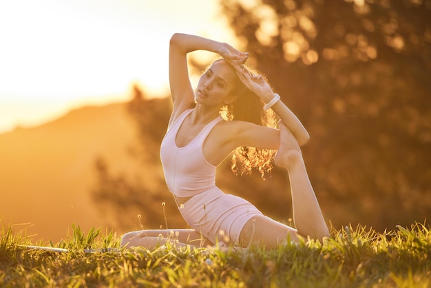 Yoga is de sleutel tot een gezond leven Volledige opname van een aantrekkelijke jonge vrouw die op een zonnige ochtend buiten yoga beoefent