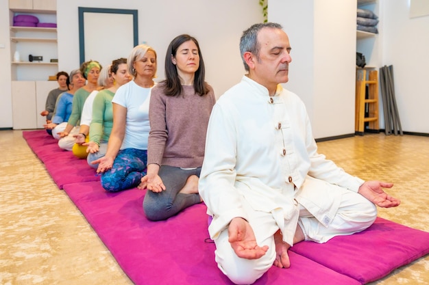 Yoga leraar die een meditatie leidt in een gemeenschap