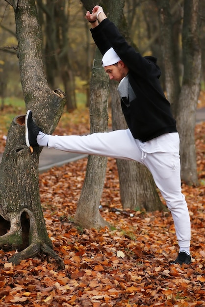 Yoga man sport in autumn park sit on a mat